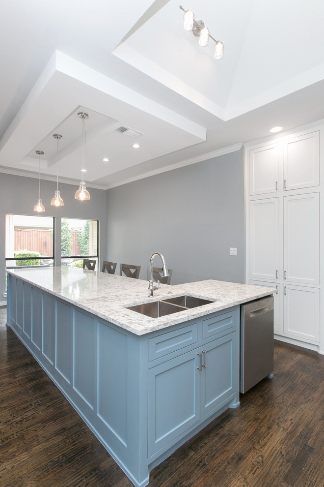 This is an example of a large traditional u-shaped open plan kitchen in Dallas with a double-bowl sink, shaker cabinets, white cabinets, quartz worktops, white splashback, stone slab splashback, stainless steel appliances, dark hardwood flooring, an island, brown floors and turquoise worktops.