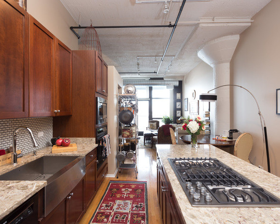 Photo of a medium sized contemporary galley enclosed kitchen in Chicago with a submerged sink, flat-panel cabinets, medium wood cabinets, granite worktops, white splashback, cement tile splashback, stainless steel appliances, medium hardwood flooring and an island.
