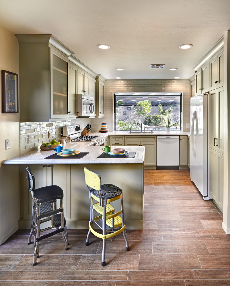 Exemple d'une cuisine chic en U avec un placard à porte shaker, des portes de placard beiges, une crédence beige et un électroménager blanc.