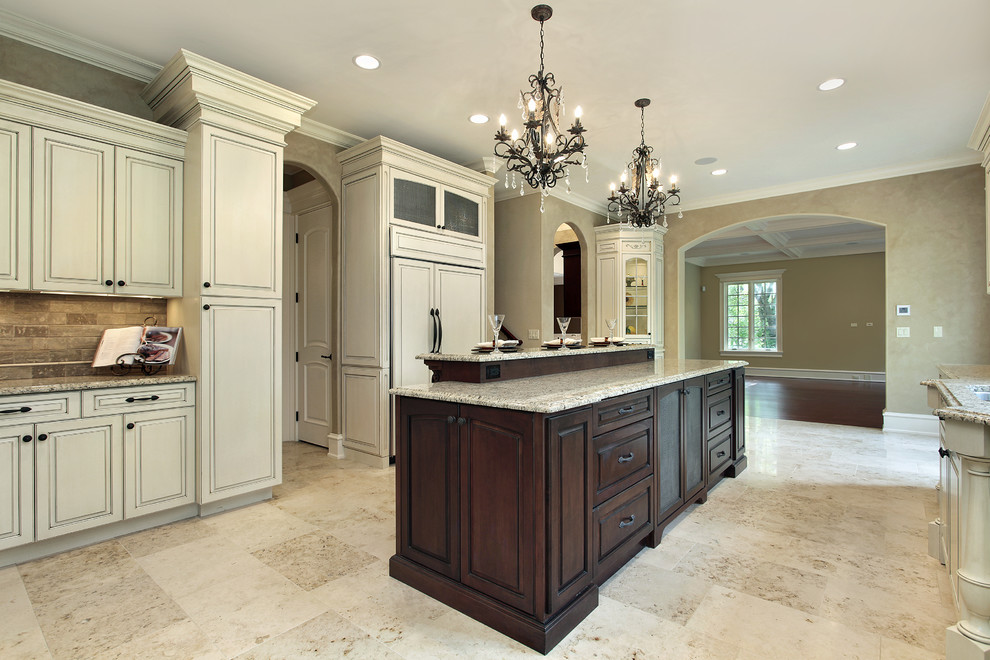 Inspiration for a large transitional u-shaped limestone floor eat-in kitchen remodel in Atlanta with an undermount sink, raised-panel cabinets, beige cabinets, granite countertops, brown backsplash, stone tile backsplash, paneled appliances and an island
