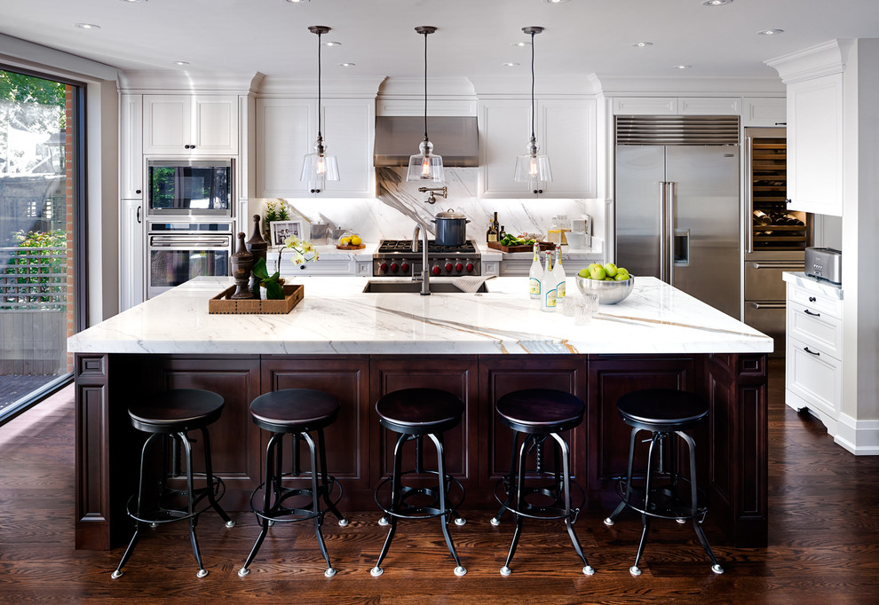 Klassische Küche mit Unterbauwaschbecken, Schrankfronten mit vertiefter Füllung, weißen Schränken, Küchenrückwand in Weiß, Rückwand aus Stein, Küchengeräten aus Edelstahl, dunklem Holzboden und Kücheninsel in Toronto