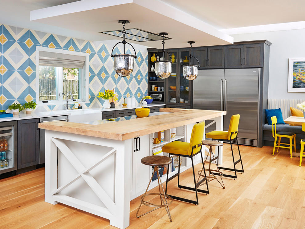 Large transitional u-shaped medium tone wood floor open concept kitchen photo in Other with a farmhouse sink, shaker cabinets, gray cabinets, wood countertops, blue backsplash, ceramic backsplash, stainless steel appliances and an island