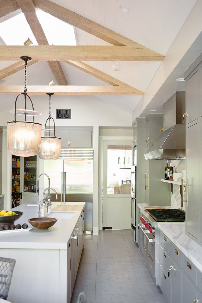 Farmhouse kitchen in Los Angeles with a submerged sink, green cabinets, an island, grey floors and white worktops.
