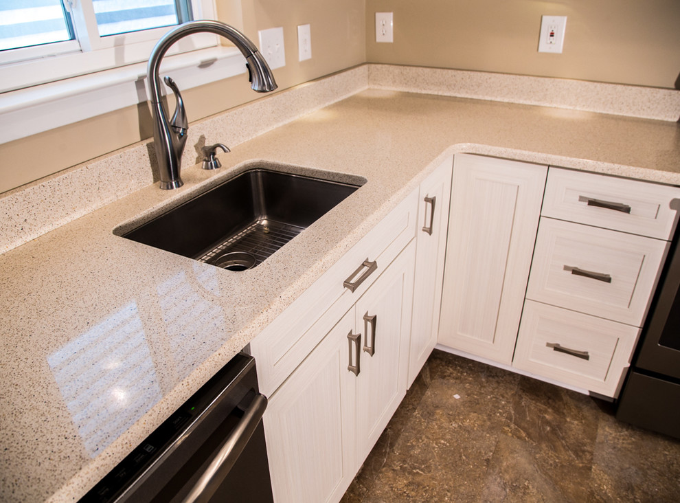 Example of a transitional u-shaped kitchen design in Baltimore with an undermount sink, recessed-panel cabinets, white cabinets, granite countertops, beige backsplash, stainless steel appliances and a peninsula