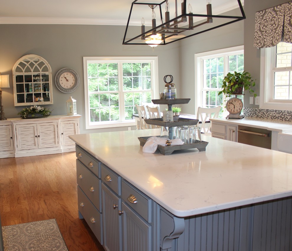 Exempel på ett stort lantligt kök, med en rustik diskho, luckor med infälld panel, vita skåp, marmorbänkskiva, flerfärgad stänkskydd, stänkskydd i mosaik, mellanmörkt trägolv, en köksö och brunt golv