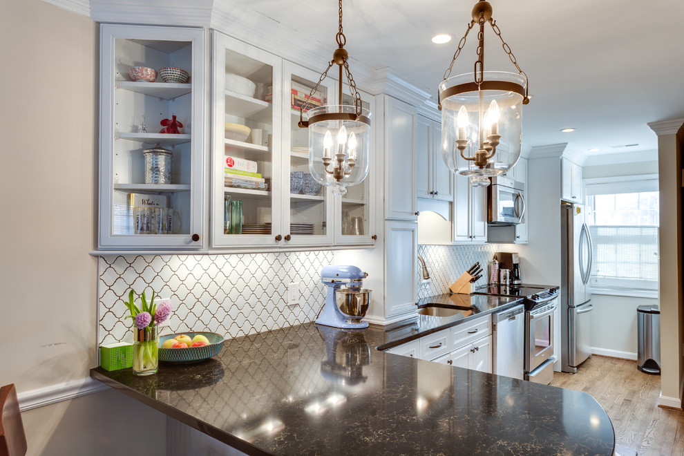Example of a mid-sized transitional l-shaped medium tone wood floor eat-in kitchen design in DC Metro with an undermount sink, flat-panel cabinets, white cabinets, quartz countertops, white backsplash, stainless steel appliances and a peninsula