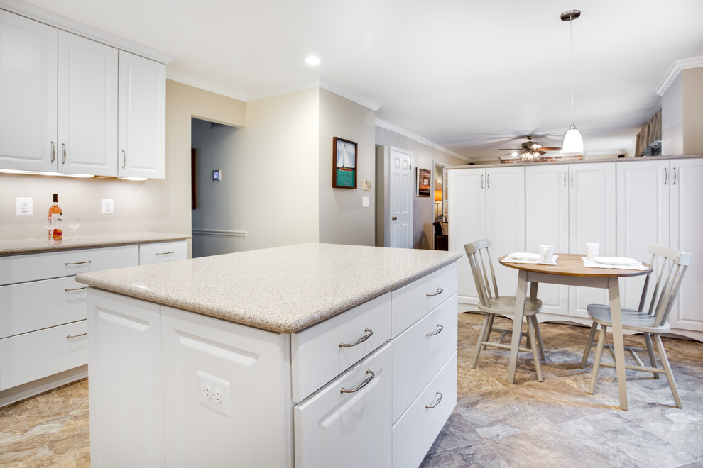 This is an example of a medium sized classic u-shaped kitchen in DC Metro with a submerged sink, raised-panel cabinets, white cabinets, glass worktops, white splashback, white appliances and an island.