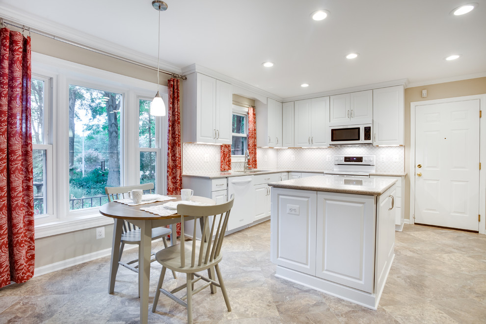 Medium sized traditional u-shaped kitchen in DC Metro with a submerged sink, raised-panel cabinets, white cabinets, glass worktops, white splashback, white appliances and an island.