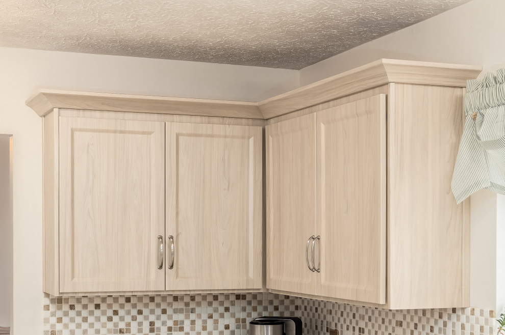 Modelo de cocina comedor clásica renovada de tamaño medio con armarios estilo shaker y puertas de armario de madera clara