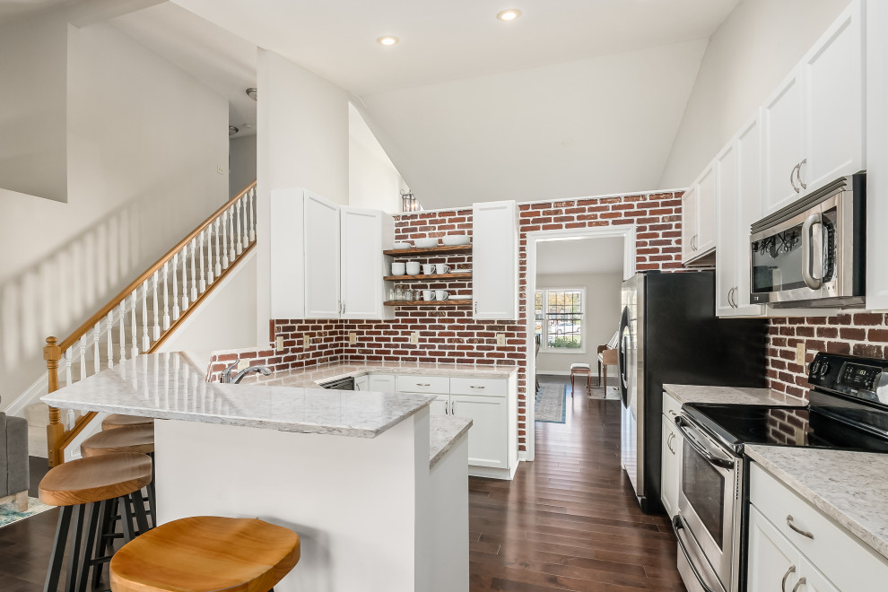 Example of a mid-sized transitional u-shaped eat-in kitchen design in Columbus with shaker cabinets, white cabinets, quartz countertops and brick backsplash
