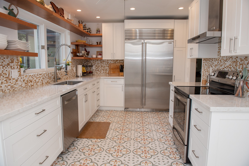 Exemple d'une arrière-cuisine parallèle chic de taille moyenne avec un évier encastré, des portes de placard blanches, un plan de travail en granite, un électroménager en acier inoxydable et un sol en carrelage de céramique.