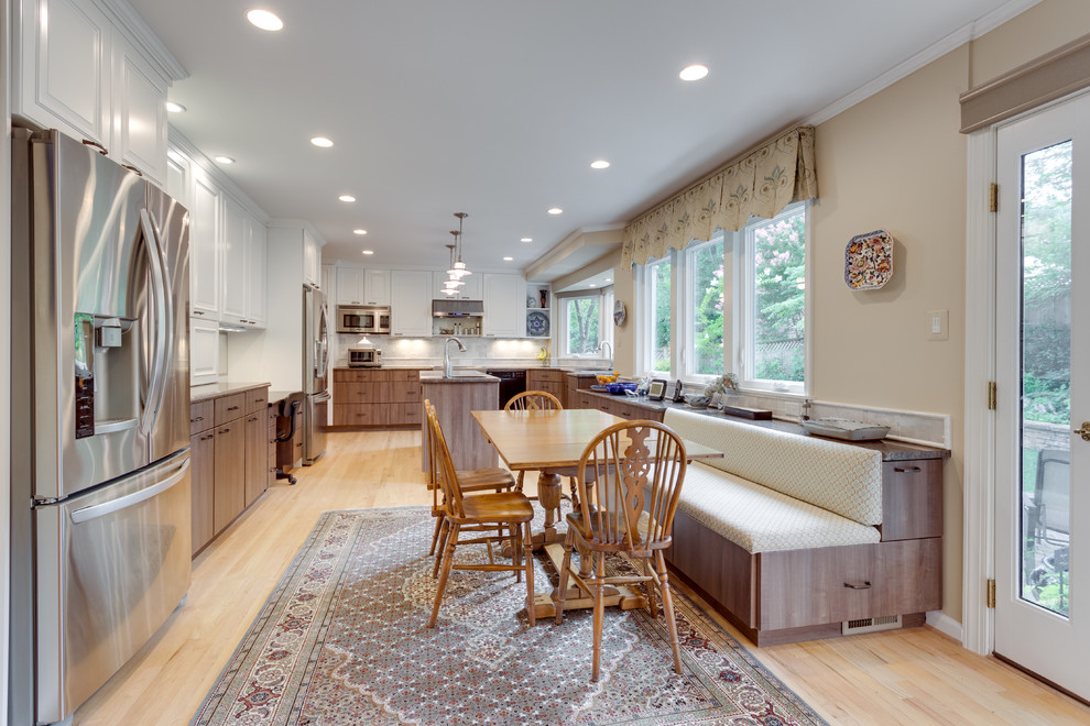 Traditional u-shaped kitchen/diner in DC Metro with a submerged sink, granite worktops, stainless steel appliances, light hardwood flooring and an island.