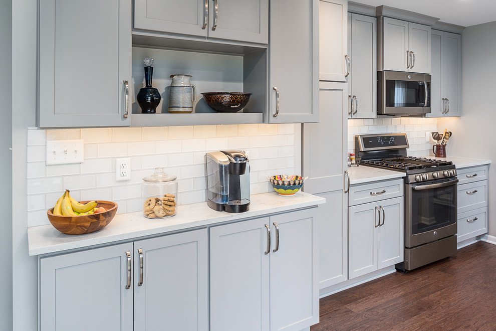 Inspiration for a mid-sized transitional u-shaped laminate floor and brown floor eat-in kitchen remodel in Other with an undermount sink, recessed-panel cabinets, gray cabinets, quartzite countertops, white backsplash, subway tile backsplash, stainless steel appliances and no island