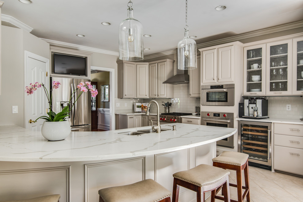 Large traditional l-shaped kitchen/diner in Charlotte with a double-bowl sink, raised-panel cabinets, grey cabinets, engineered stone countertops, grey splashback, metro tiled splashback, stainless steel appliances, porcelain flooring and a breakfast bar.