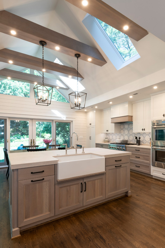 Photo of a large traditional l-shaped kitchen in DC Metro with a belfast sink, light wood cabinets, multi-coloured splashback, stainless steel appliances, medium hardwood flooring, brown floors, white worktops, exposed beams and recessed-panel cabinets.