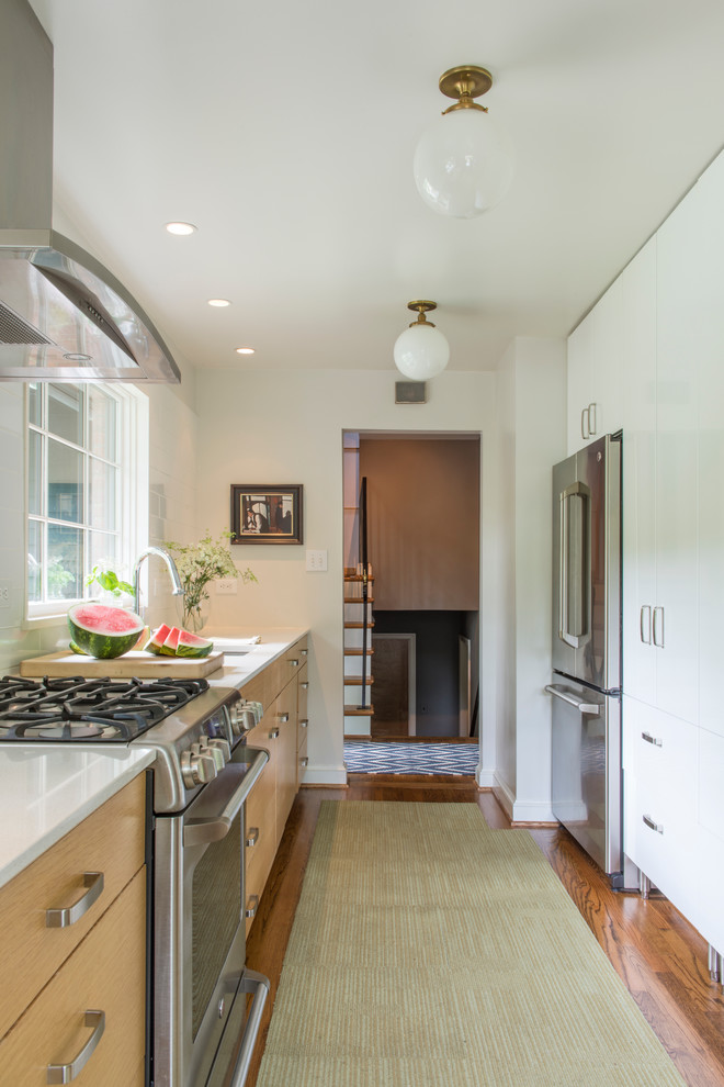 Medium sized traditional galley enclosed kitchen in DC Metro with a submerged sink, flat-panel cabinets, light wood cabinets, engineered stone countertops, stainless steel appliances, medium hardwood flooring and no island.