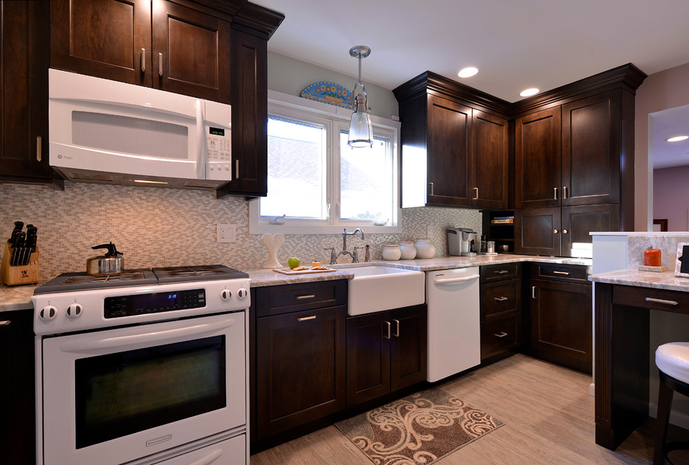 Example of a mid-sized transitional galley light wood floor enclosed kitchen design in New York with a farmhouse sink, shaker cabinets, dark wood cabinets, quartz countertops, multicolored backsplash, mosaic tile backsplash, white appliances and no island