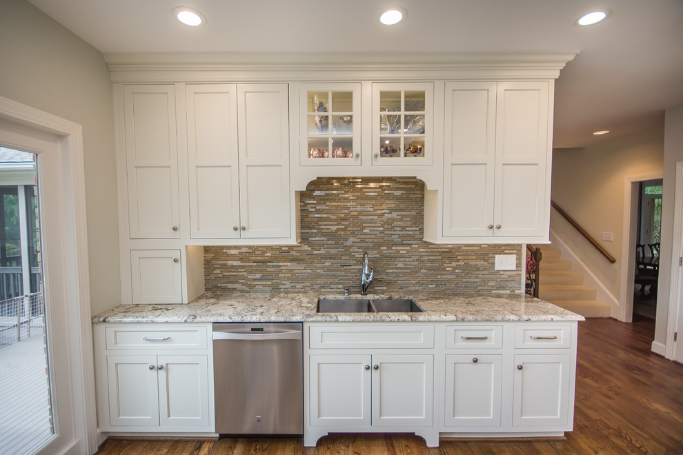 Inspiration for a huge transitional l-shaped medium tone wood floor eat-in kitchen remodel in Birmingham with an undermount sink, recessed-panel cabinets, white cabinets, granite countertops, multicolored backsplash, glass tile backsplash, stainless steel appliances and an island