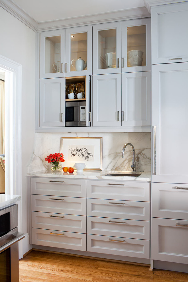 Exempel på ett klassiskt kök, med en undermonterad diskho, luckor med infälld panel, grå skåp, marmorbänkskiva, vitt stänkskydd, integrerade vitvaror och stänkskydd i marmor