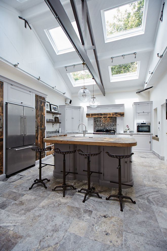 Bild på ett stort vintage l-kök, med grå skåp, rostfria vitvaror, en köksö, luckor med infälld panel, flerfärgad stänkskydd, stänkskydd i sten och flerfärgat golv