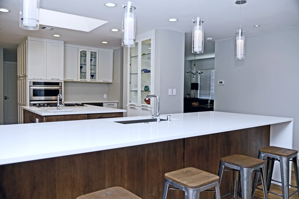 Exempel på ett stort klassiskt kök och matrum, med en undermonterad diskho, skåp i shakerstil, bänkskiva i kvarts, rostfria vitvaror, flera köksöar, vita skåp och mellanmörkt trägolv