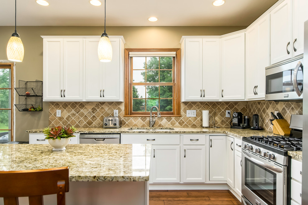 Inspiration for a medium sized traditional l-shaped kitchen/diner in Columbus with shaker cabinets, white cabinets, stainless steel appliances and an island.