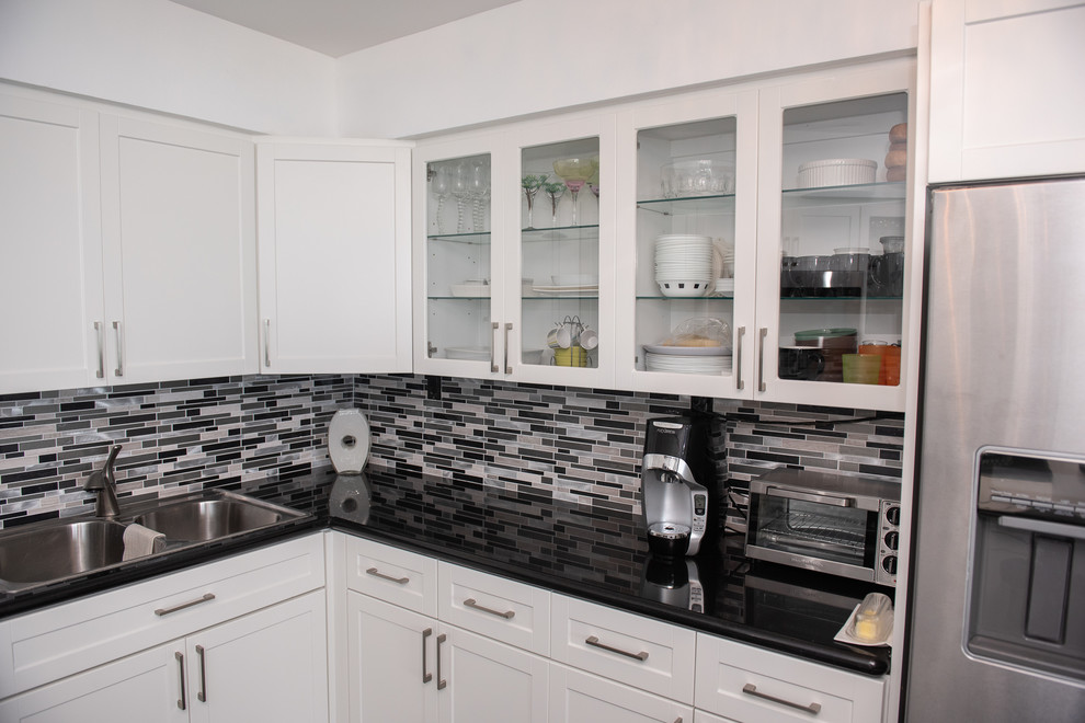 Medium sized traditional u-shaped kitchen/diner in Miami with white cabinets and stainless steel appliances.