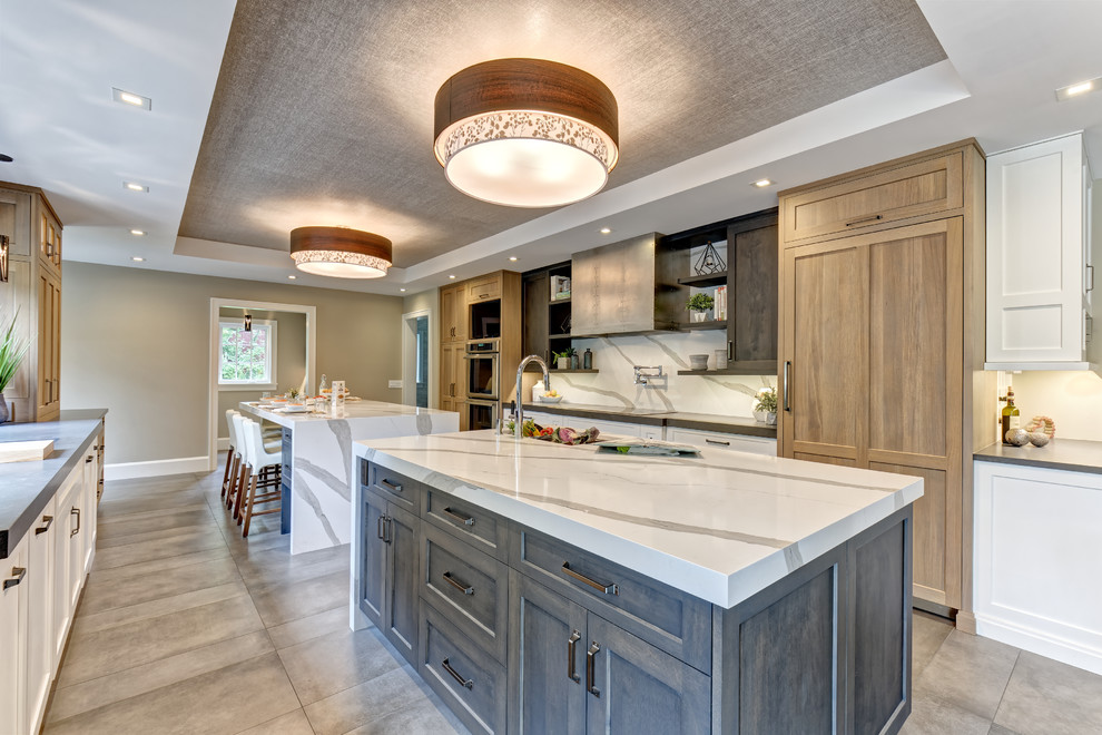 Example of a large transitional galley porcelain tile and brown floor eat-in kitchen design in New York with an undermount sink, shaker cabinets, gray cabinets, quartz countertops, white backsplash, stone slab backsplash, stainless steel appliances, two islands and white countertops