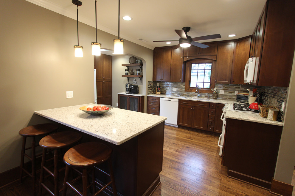 Example of a mid-sized transitional l-shaped medium tone wood floor and brown floor kitchen pantry design in Cleveland with an undermount sink, shaker cabinets, medium tone wood cabinets, quartz countertops, brown backsplash, glass tile backsplash, white appliances and an island