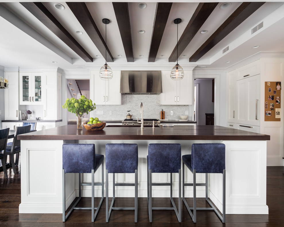 Eat-in kitchen - mid-sized transitional galley dark wood floor eat-in kitchen idea in Boston with recessed-panel cabinets, white cabinets, wood countertops, gray backsplash, stainless steel appliances, an island, an undermount sink and stone tile backsplash