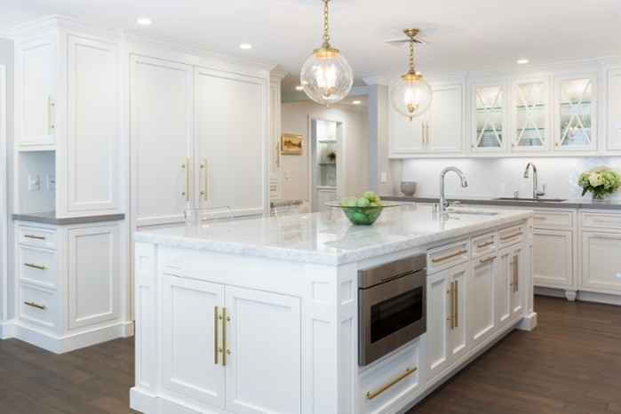 Example of a large transitional u-shaped dark wood floor eat-in kitchen design in Boston with an undermount sink, recessed-panel cabinets, white cabinets, white backsplash, white appliances and an island