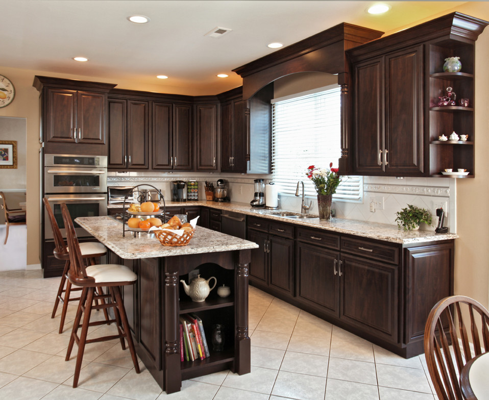 Large transitional l-shaped ceramic tile eat-in kitchen photo in Philadelphia with a double-bowl sink, raised-panel cabinets, brown cabinets, quartzite countertops, white backsplash, porcelain backsplash, stainless steel appliances and an island