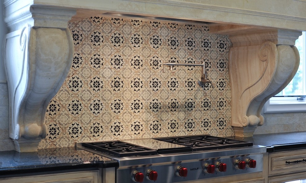 Aménagement d'une cuisine méditerranéenne en bois vieilli avec une crédence multicolore, une crédence en mosaïque, un électroménager en acier inoxydable, plan de travail noir et un plan de travail en granite.