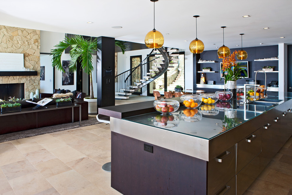 Example of a large trendy single-wall beige floor and travertine floor eat-in kitchen design in Los Angeles with a drop-in sink, flat-panel cabinets, dark wood cabinets, stainless steel countertops, stainless steel appliances and an island