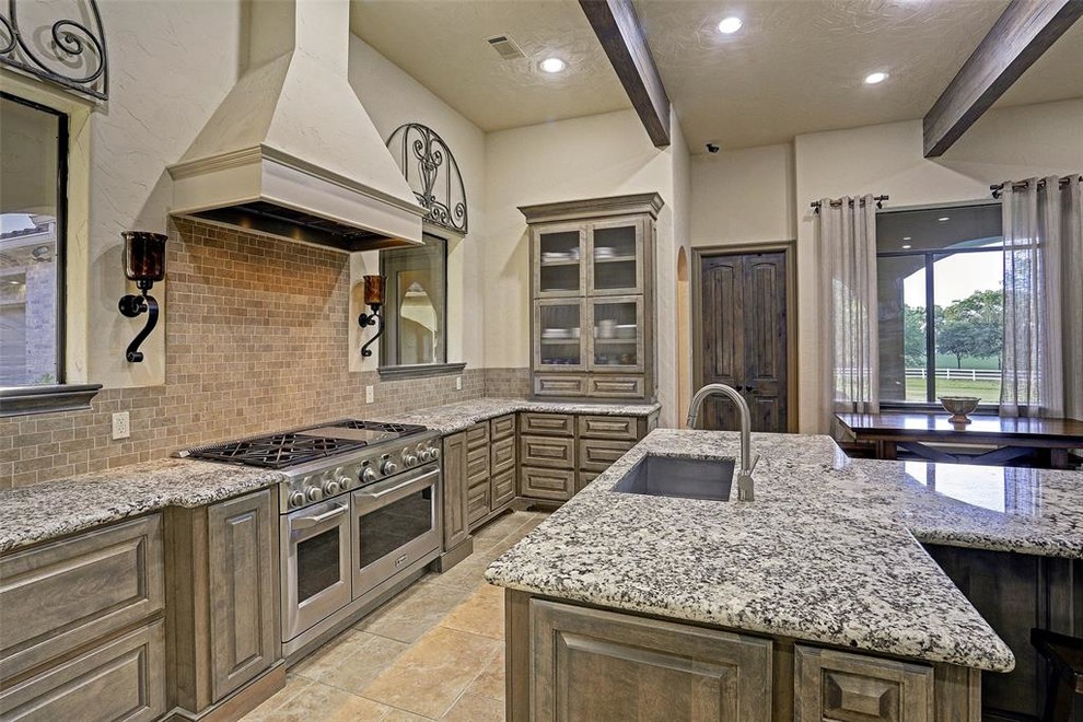 Huge transitional l-shaped ceramic tile and beige floor eat-in kitchen photo in Houston with an undermount sink, recessed-panel cabinets, medium tone wood cabinets, granite countertops, brown backsplash, stone tile backsplash, stainless steel appliances, an island and gray countertops