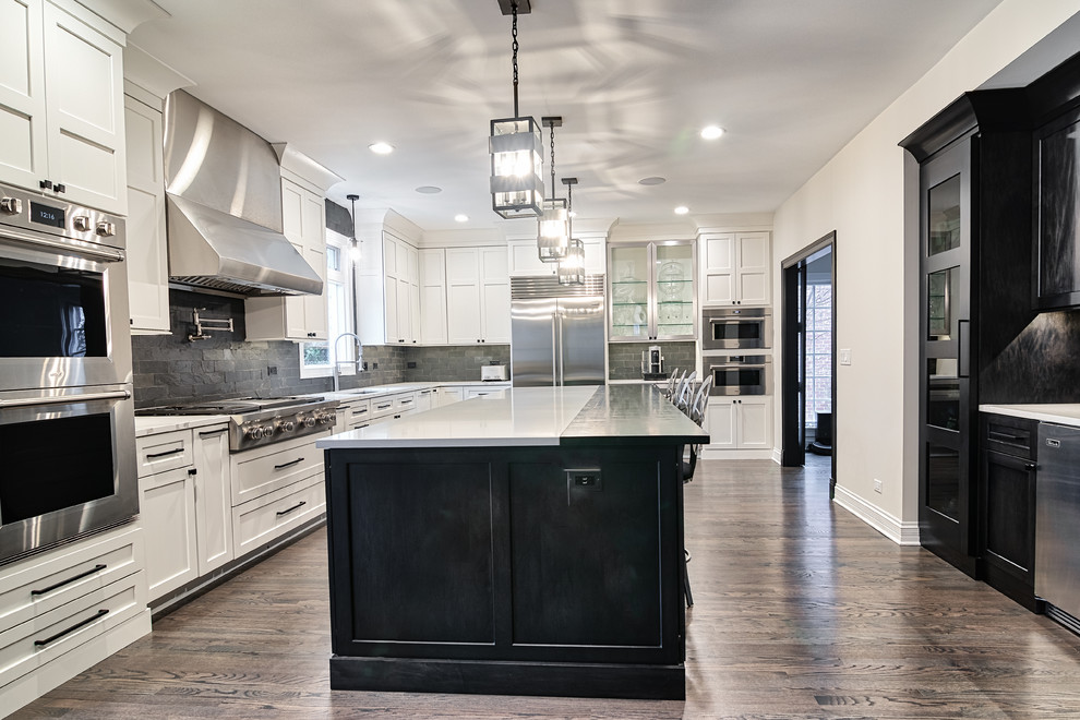 Inspiration for a large traditional u-shaped kitchen in Nashville with a submerged sink, shaker cabinets, dark wood cabinets, composite countertops, black splashback, brick splashback, stainless steel appliances, medium hardwood flooring, an island, brown floors and white worktops.