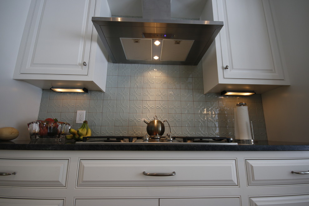 Inspiration for a large classic enclosed kitchen in Cleveland with a submerged sink, beaded cabinets, white cabinets, quartz worktops, blue splashback, ceramic splashback, stainless steel appliances, medium hardwood flooring and an island.