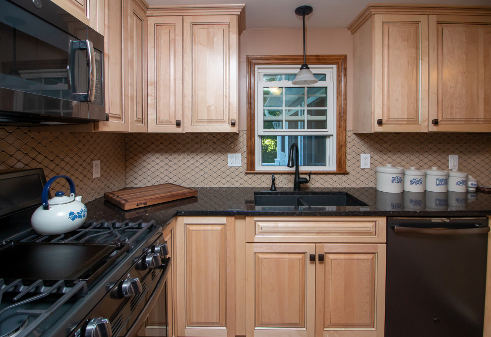 ボストンにあるお手頃価格の広いトランジショナルスタイルのおしゃれなキッチン (ダブルシンク、レイズドパネル扉のキャビネット、淡色木目調キャビネット、クオーツストーンカウンター、茶色いキッチンパネル、セラミックタイルのキッチンパネル、黒い調理設備、クッションフロア、茶色い床、黒いキッチンカウンター) の写真