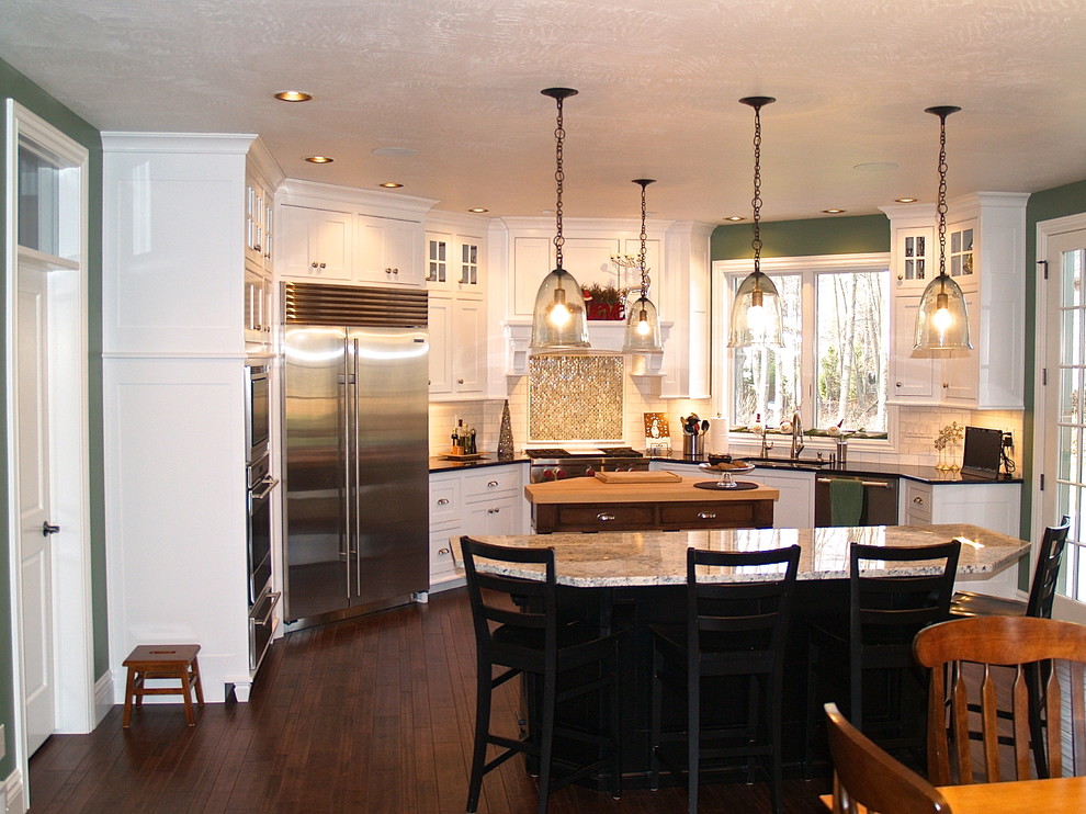 Immagine di una cucina classica con paraspruzzi bianco, paraspruzzi con piastrelle in pietra, elettrodomestici in acciaio inossidabile, parquet scuro e 2 o più isole