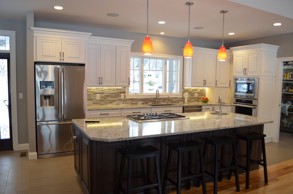 ボストンにある高級な広いトランジショナルスタイルのおしゃれなキッチン (アンダーカウンターシンク、レイズドパネル扉のキャビネット、クオーツストーンカウンター、シルバーの調理設備、白いキャビネット、マルチカラーのキッチンパネル、ボーダータイルのキッチンパネル、淡色無垢フローリング、茶色い床) の写真