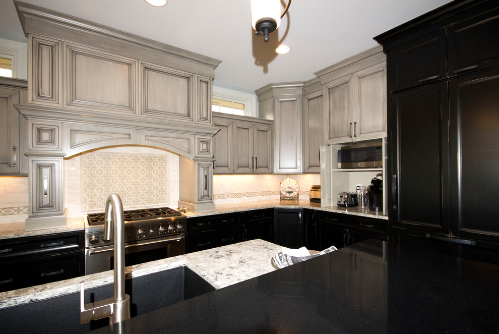 Open concept kitchen - large traditional l-shaped dark wood floor and brown floor open concept kitchen idea in Cincinnati with an undermount sink, raised-panel cabinets, gray cabinets, quartzite countertops, white backsplash, ceramic backsplash, stainless steel appliances and an island