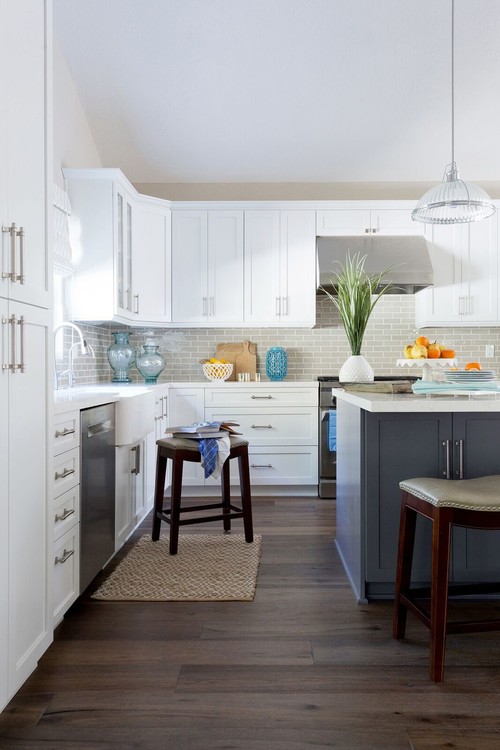 Canadian kitchen with white shaker cabinets and a navy-blue island, accented by stainless steel appliances—highlighting best kitchen cabinet colors Canada.