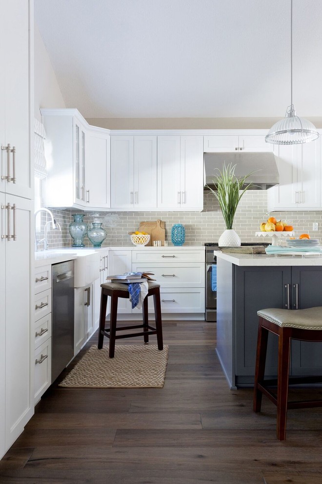 Inspiration for a huge transitional l-shaped medium tone wood floor open concept kitchen remodel in Los Angeles with a farmhouse sink, shaker cabinets, white cabinets, quartz countertops, gray backsplash, subway tile backsplash, stainless steel appliances and an island