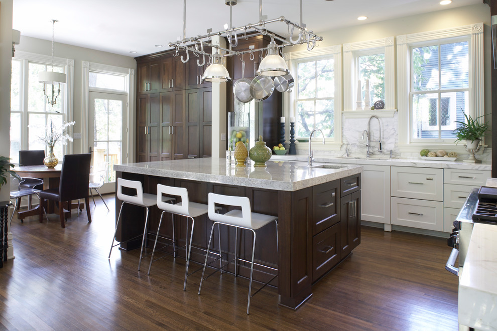 This is an example of a large classic l-shaped open plan kitchen in Chicago with a submerged sink, shaker cabinets, dark wood cabinets, marble worktops, beige splashback, integrated appliances, dark hardwood flooring and an island.