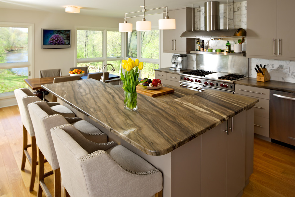 Eat-in kitchen - mid-sized transitional l-shaped light wood floor and brown floor eat-in kitchen idea in New York with an island, flat-panel cabinets, gray cabinets, granite countertops, white backsplash, subway tile backsplash, stainless steel appliances and an undermount sink