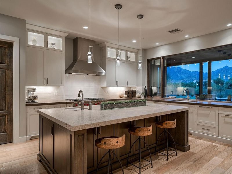 Example of a mid-sized transitional u-shaped light wood floor and beige floor eat-in kitchen design in Phoenix with an undermount sink, shaker cabinets, white cabinets, granite countertops, white backsplash, subway tile backsplash, stainless steel appliances, an island and beige countertops