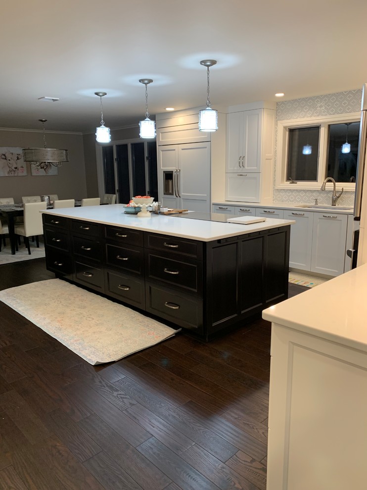 Photo of a large traditional l-shaped kitchen/diner in Other with white cabinets, engineered stone countertops and an island.