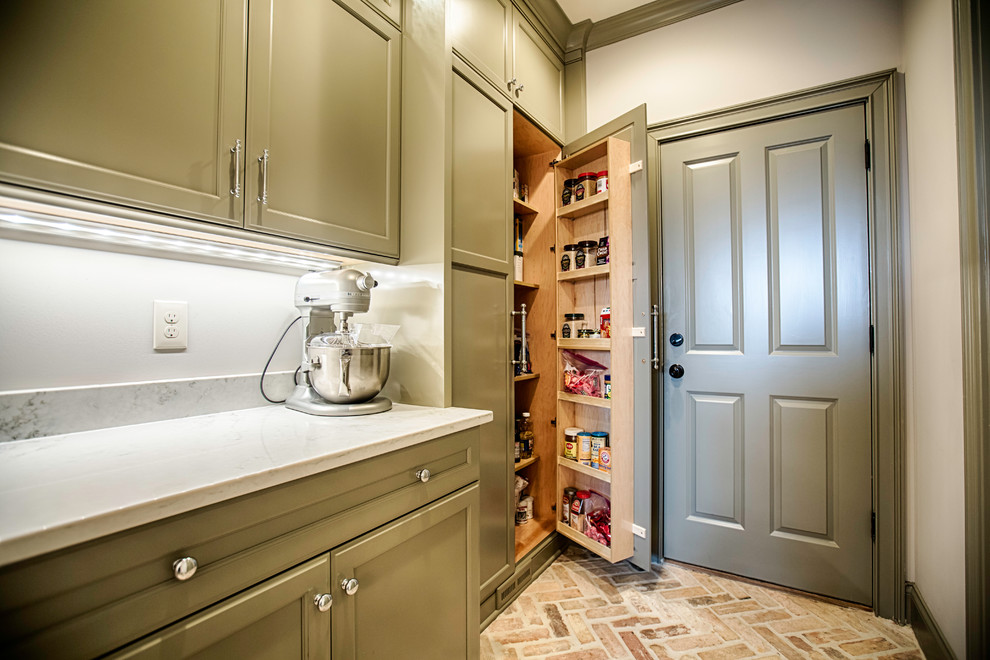 This is an example of a large classic l-shaped kitchen/diner in Birmingham with a belfast sink, flat-panel cabinets, grey cabinets, quartz worktops, grey splashback, metro tiled splashback, stainless steel appliances, brick flooring, an island and multi-coloured floors.