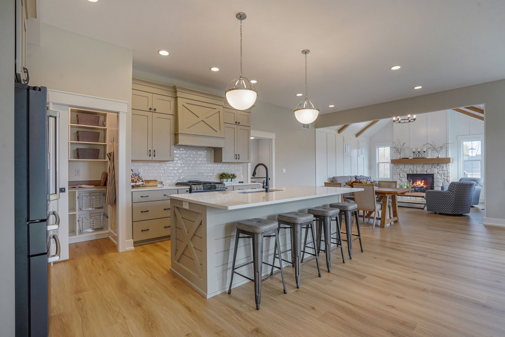 Inspiration for a country l-shaped vinyl floor and brown floor eat-in kitchen remodel in Grand Rapids with an undermount sink, shaker cabinets, beige cabinets, quartz countertops, multicolored backsplash, ceramic backsplash, black appliances, an island and white countertops