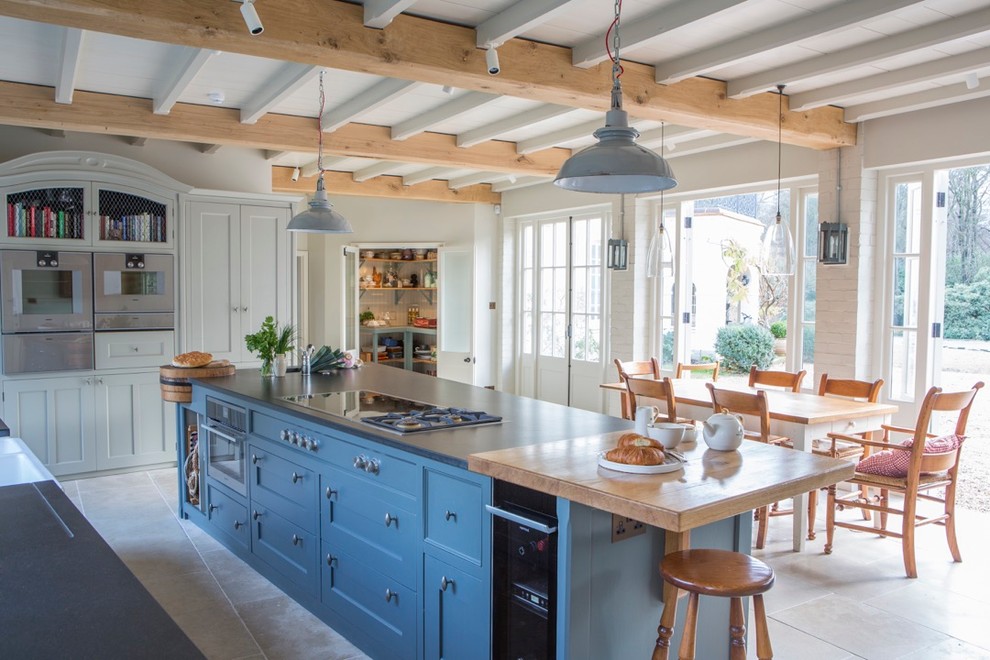 Inspiration for a farmhouse kitchen/diner in Buckinghamshire with recessed-panel cabinets, blue cabinets, stainless steel appliances and an island.